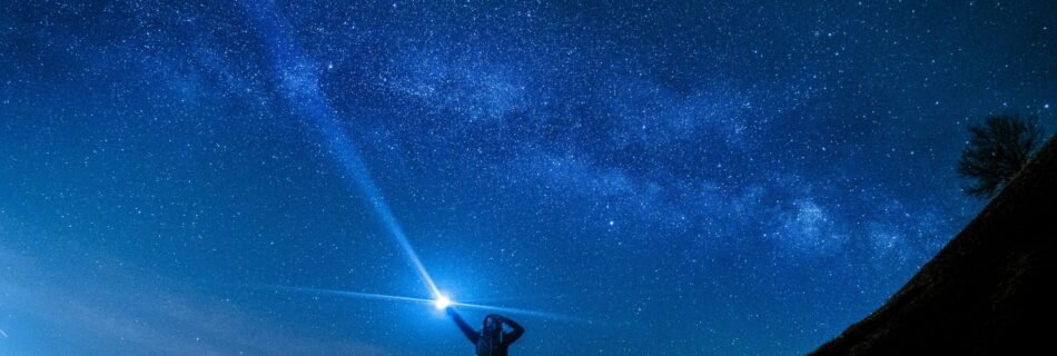 silhouette of man holding flashlight